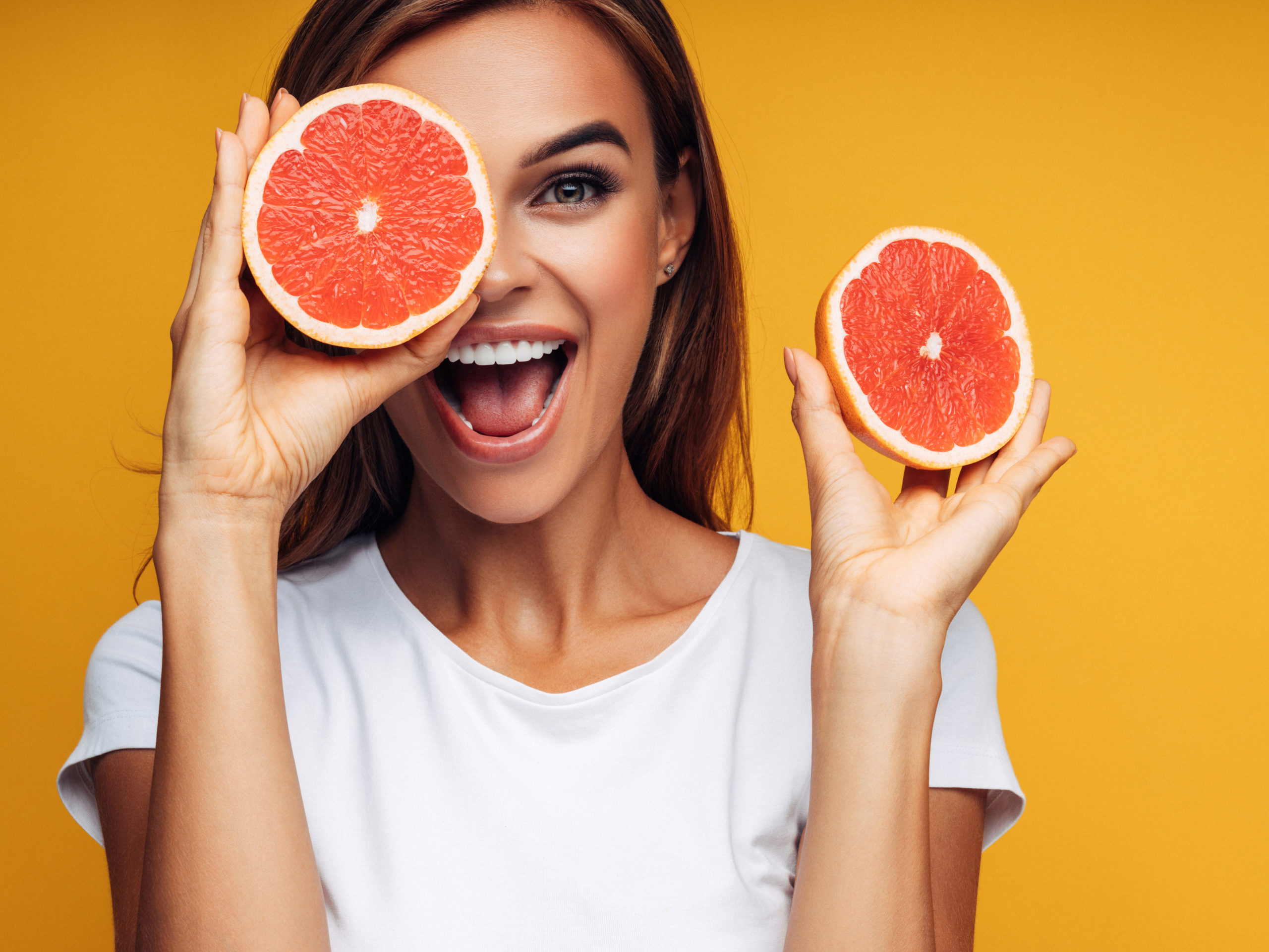 Portrait of girl holding red grapefruit
